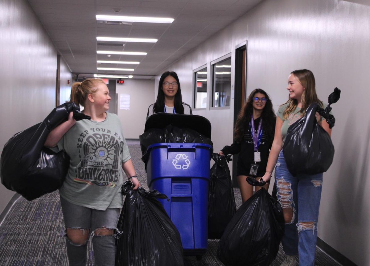 The club members split up and go in different hallways to clear the recycling bins. Then they take it outside and they repeat that a couple of times until the second floor recycling is all taken out.
