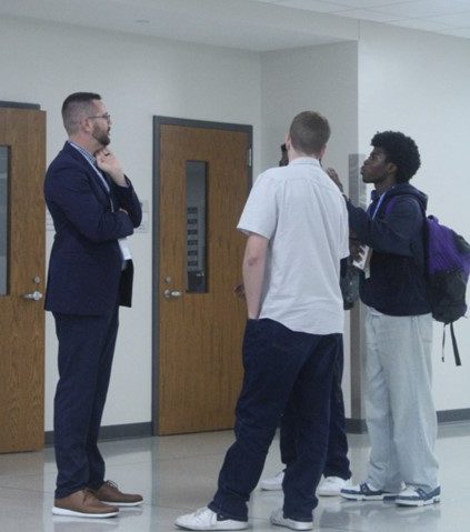 Mahan talks to three seniors outside of the business classrooms. 