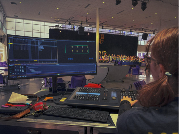 Junior Riley Petersen programs the lights for the Madrigals Dinner, taking place in the BHS cafeteria.
