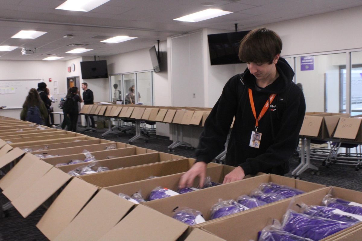 Students are getting ready for graduation by picking up their caps and gowns.